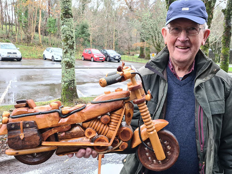 Killarney Men's Shed - Man holding a small motorbike made of wood